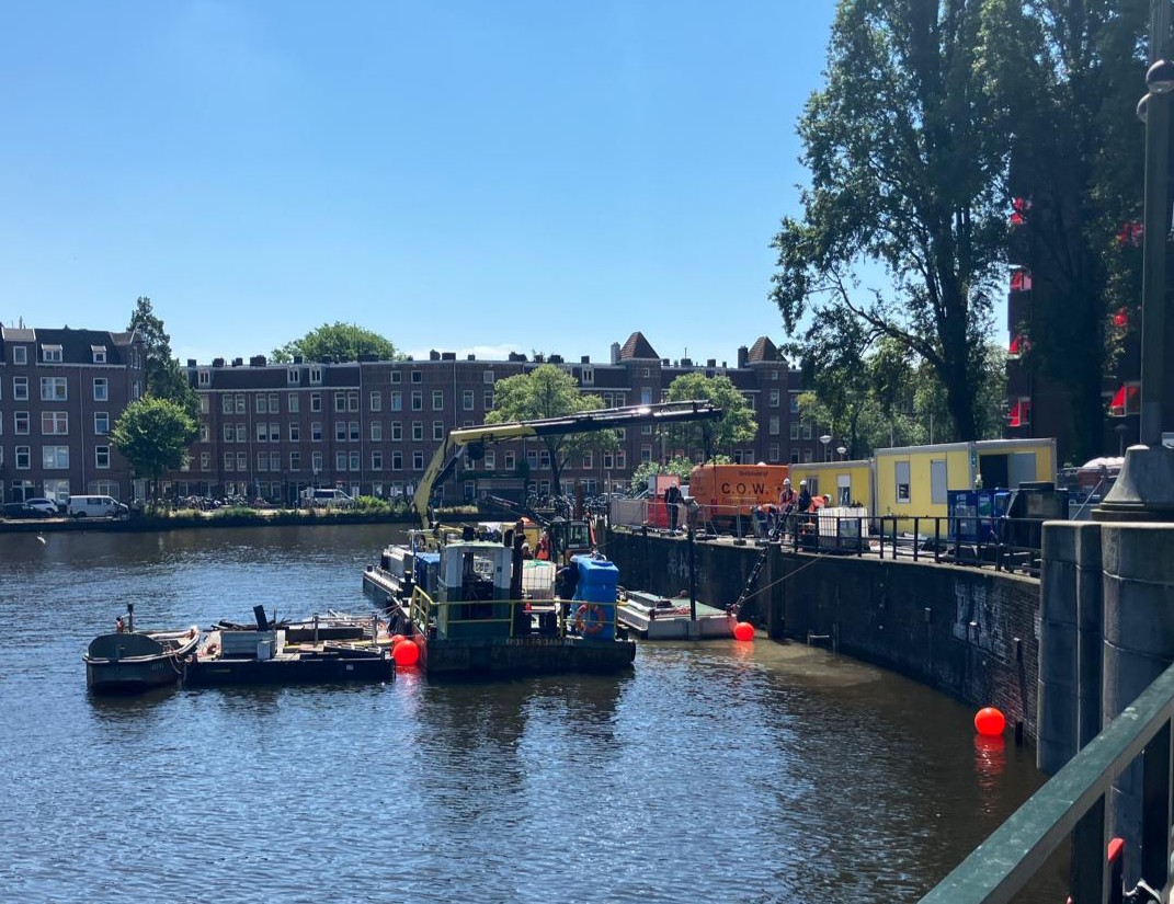 Proeftuin Buoycrete aan de Kostverlorenvaart Amsterdam, werkschip van Boskalis Nederland brengt onderwaterbetonmengsel aan in kademuren, begeleid door Sven Hokke van Citiz Partners
