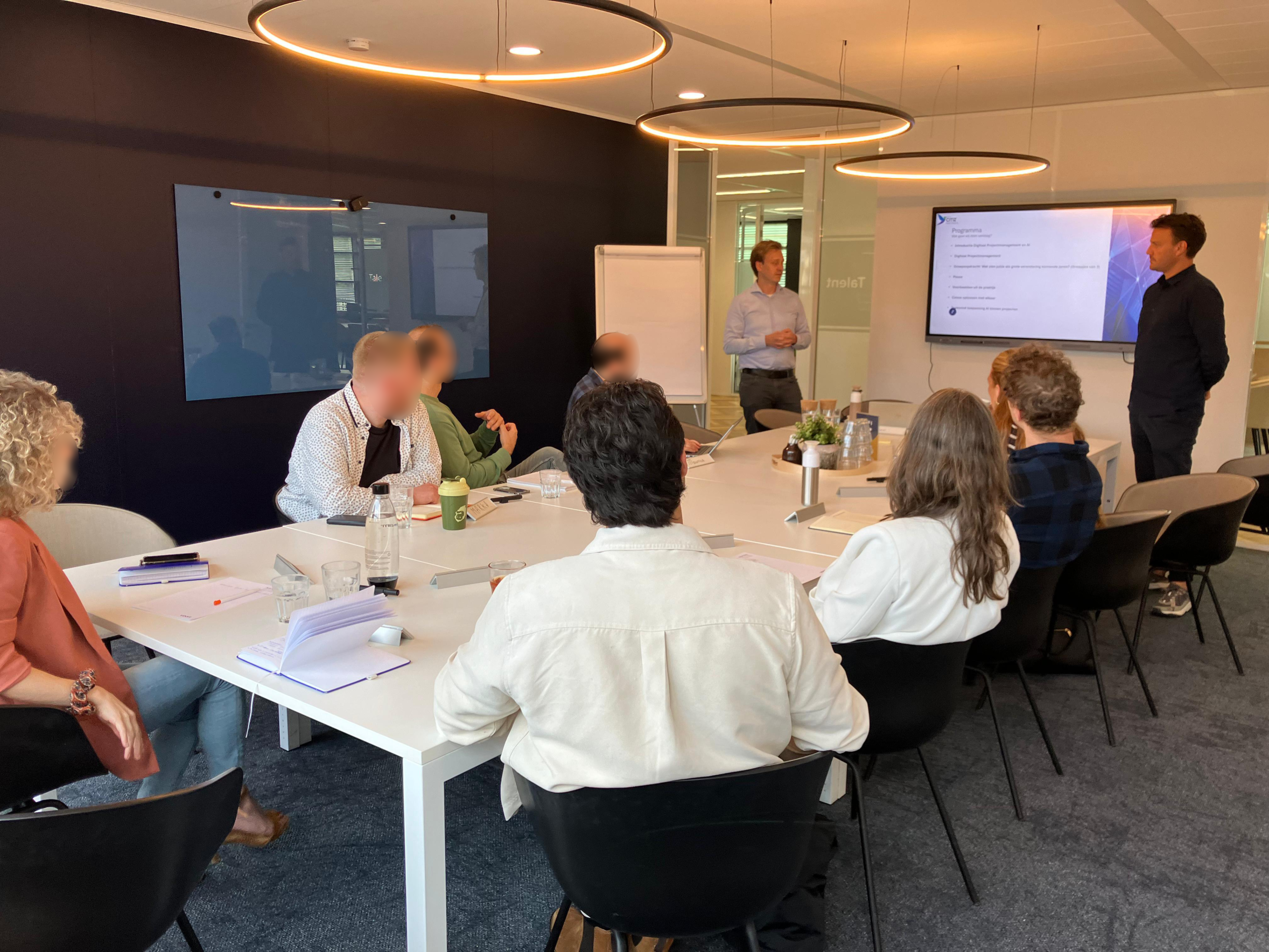 Kennisdeling over digitalisering in projectmanagement door Citiz Partners, presentatie voor een groep professionals in een moderne vergaderruimte